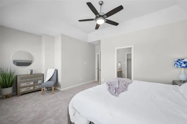 a bedroom with a bed a chair and potted plant