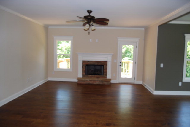 118 Laurel Ridge Forsyth, GA 31029 - Photo 6 of 21 an empty room with wooden floor a chandelier fan and windows