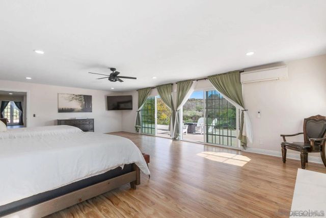a spacious bedroom with a large bed and a wooden floor