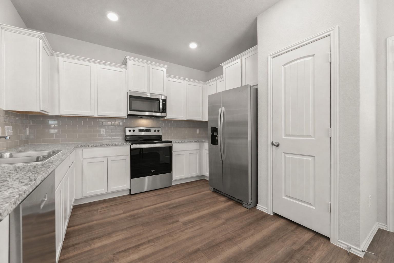 108 Pivot Drive Taylor, TX 76574 - Photo 13 of 30 a kitchen with granite countertop white cabinets and stainless steel appliances