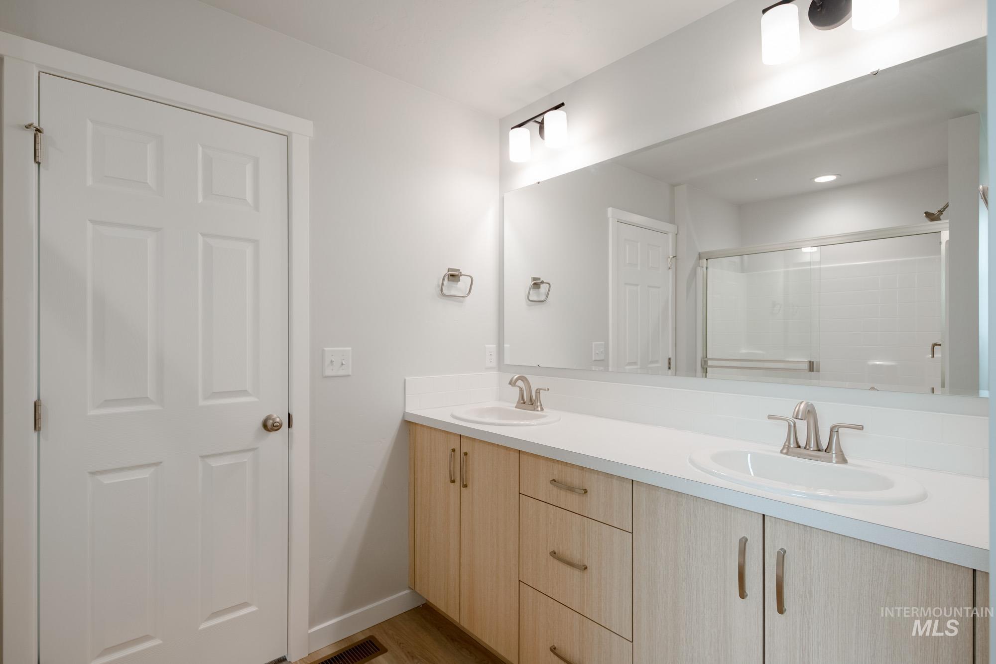 2502 West Fallon Loop Nampa, ID 83651 - Photo 20 of 21 Full bathroom featuring double vanity, a stall shower, and light wood-style floors
