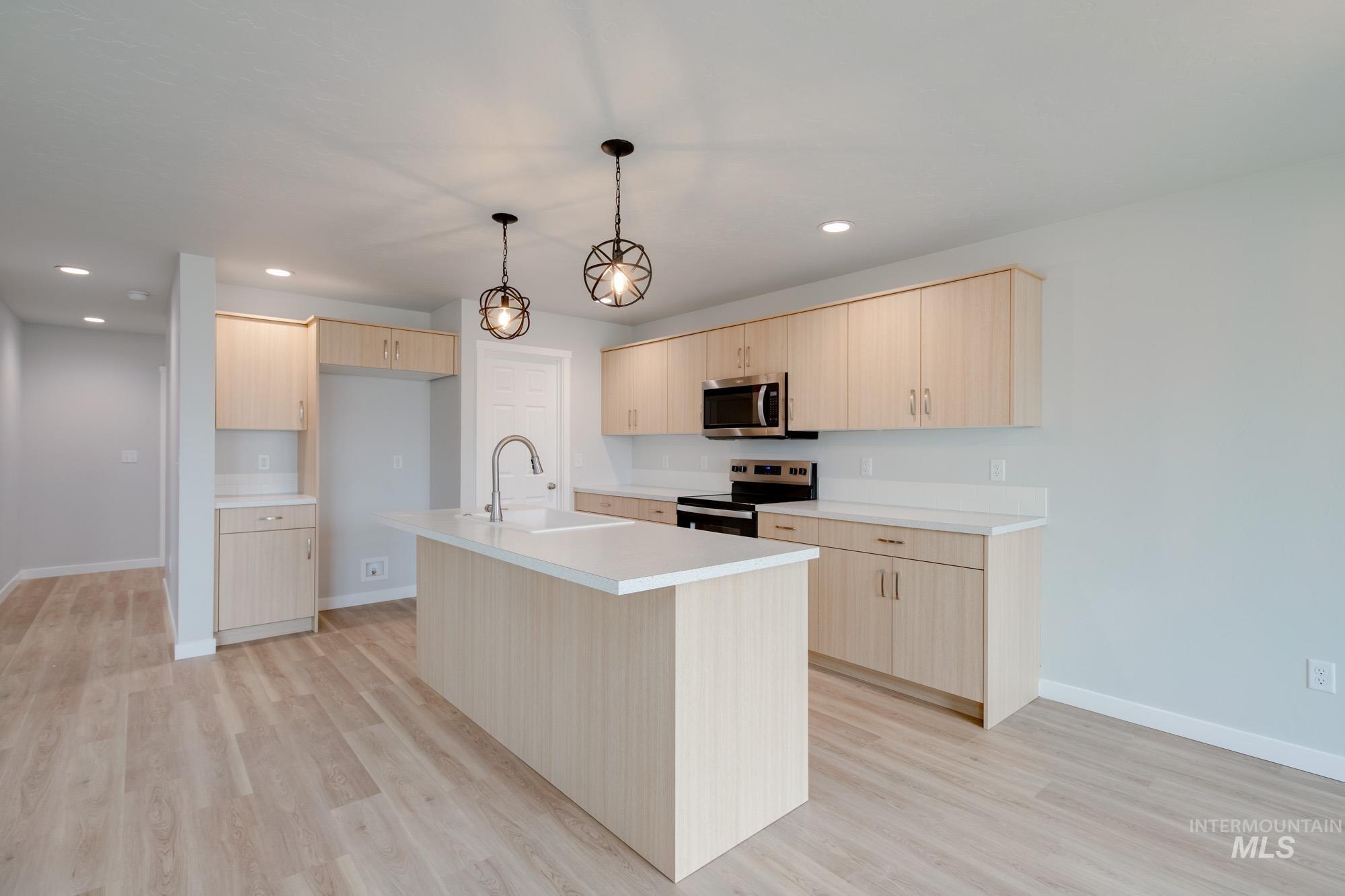 2502 West Fallon Loop Nampa, ID 83651 - Photo 5 of 21 Kitchen featuring light countertops, appliances with stainless steel finishes, light brown cabinets, pendant lighting, and recessed lighting