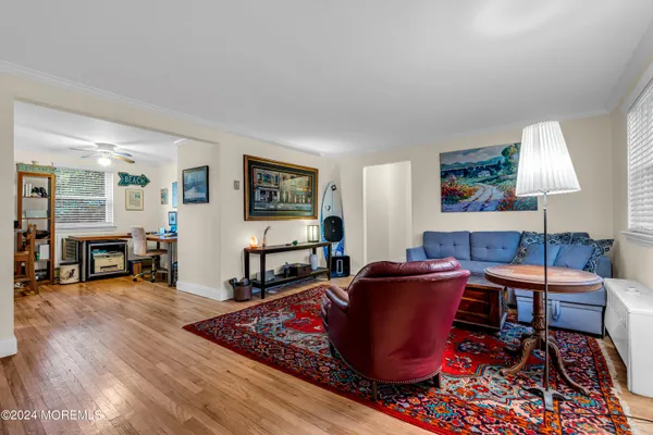 a living room with furniture a wooden floor and next to a window