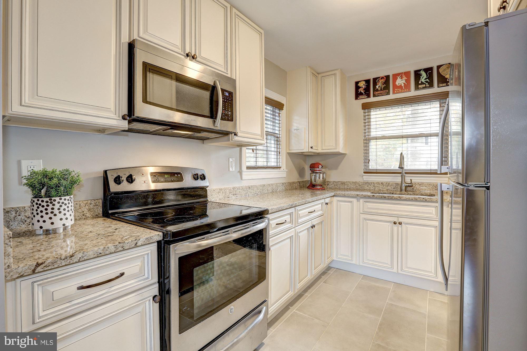 10205 Procter Street Silver Spring, MD 20901 - Photo 11 of 38 a kitchen with granite countertop cabinets stainless steel appliances and a counter space