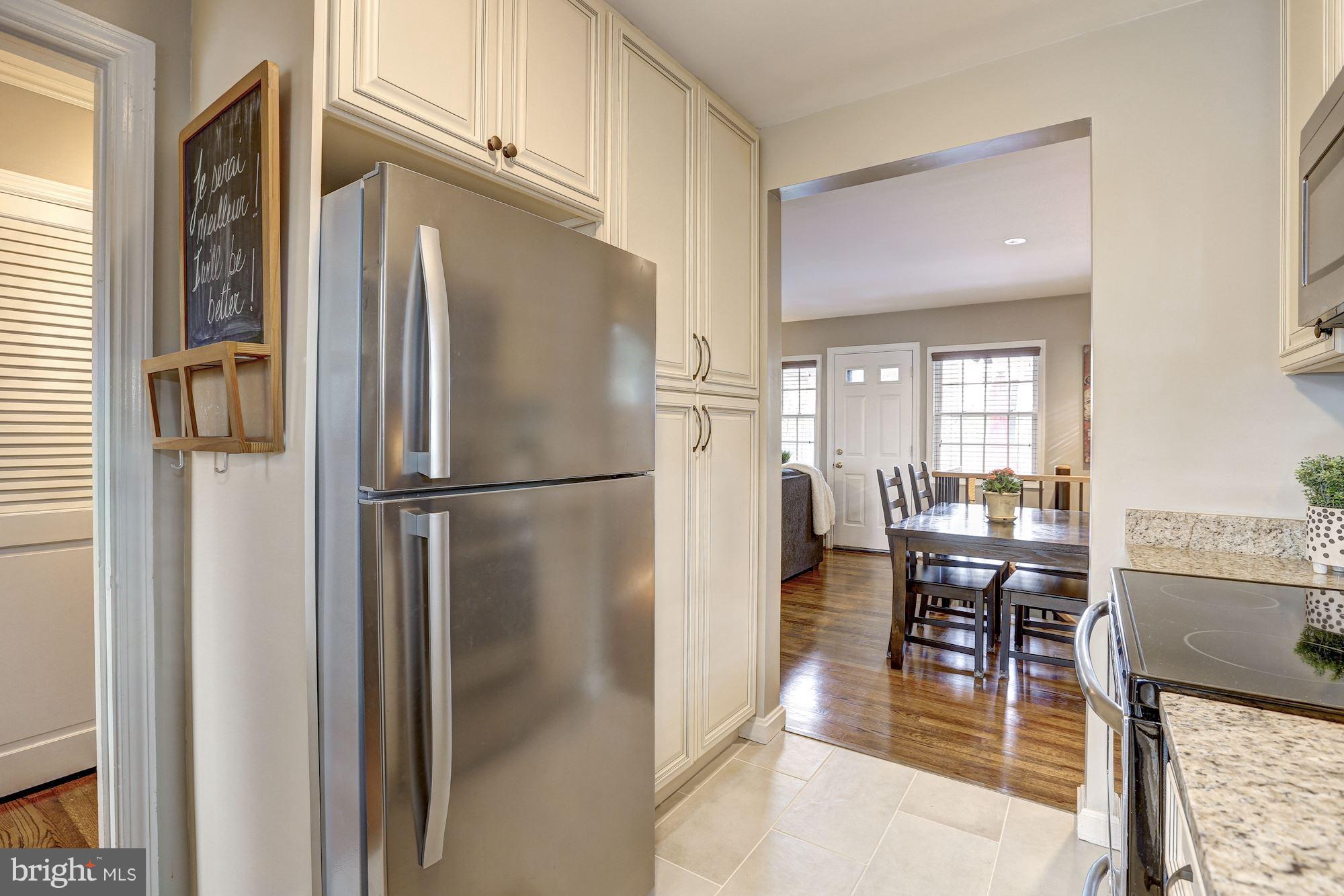 10205 Procter Street Silver Spring, MD 20901 - Photo 10 of 38 a kitchen with stainless steel appliances granite countertop refrigerator dining table and chairs