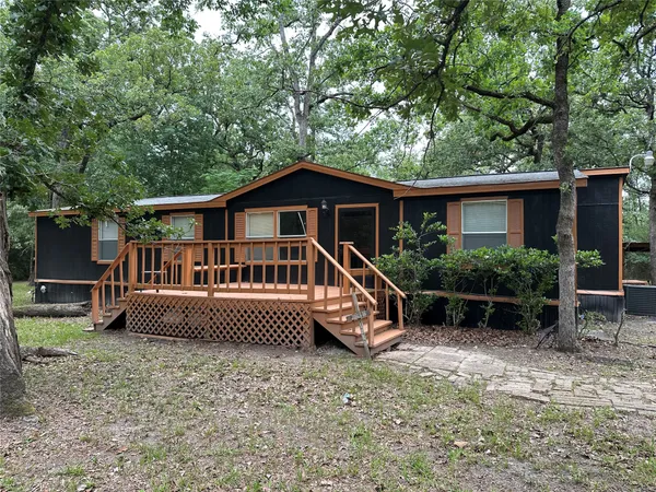 a view of house with a yard deck and a garden