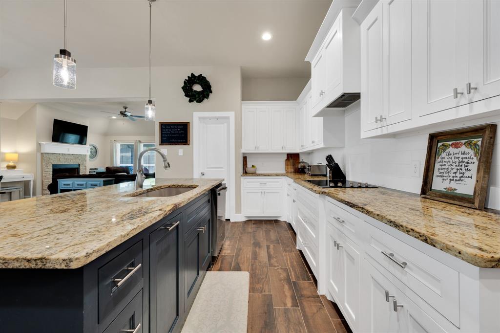 1313 Ridgeview Drive Weatherford, TX 76086 - Photo 12 of 34 Kitchen featuring a fireplace, pendant lighting, ceiling fan, dual tone cabinets, and light stone counters