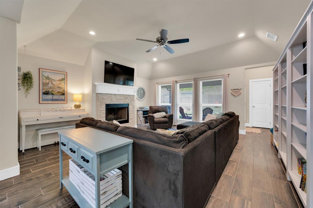 1313 Ridgeview Drive Weatherford, TX 76086 - Photo 14 of 34 Living area featuring wood finish floors, a stone fireplace, a ceiling fan, lofted ceiling, and recessed lighting
