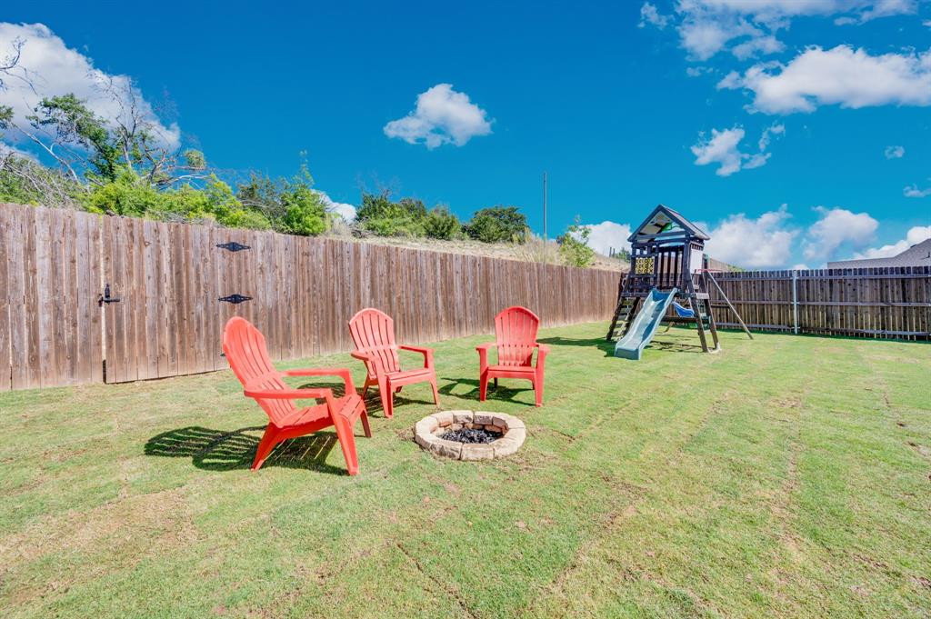 1313 Ridgeview Drive Weatherford, TX 76086 - Photo 31 of 34 Fenced backyard with an outdoor fire pit, a playground, and a patio