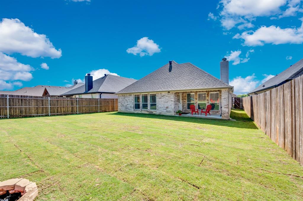 1313 Ridgeview Drive Weatherford, TX 76086 - Photo 32 of 34 Back of house featuring brick siding, a patio area, a fenced backyard, a chimney, and roof with shingles