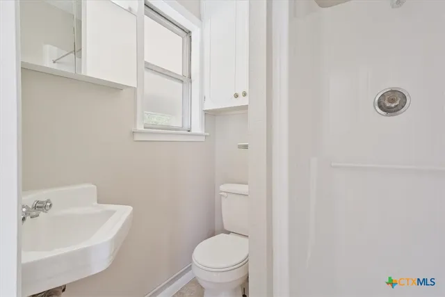 a bathroom with a sink a toilet and a window