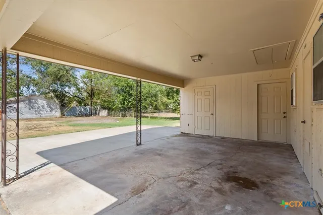 a view of an empty room with a window and a ceiling fan