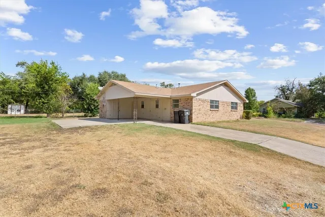 a view of white house with a yard and garage