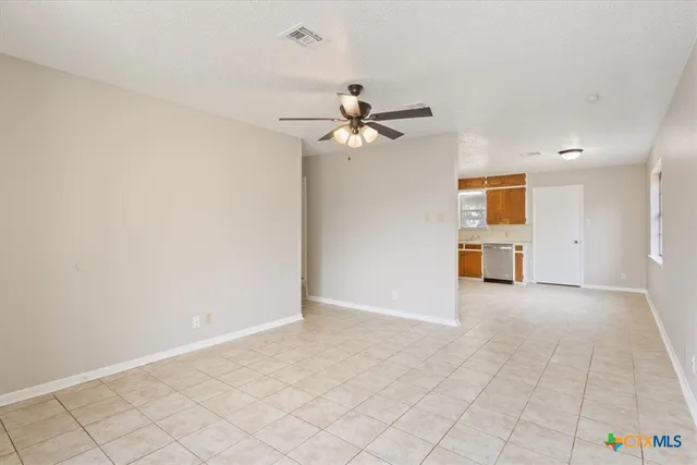 an empty room with fan and windows