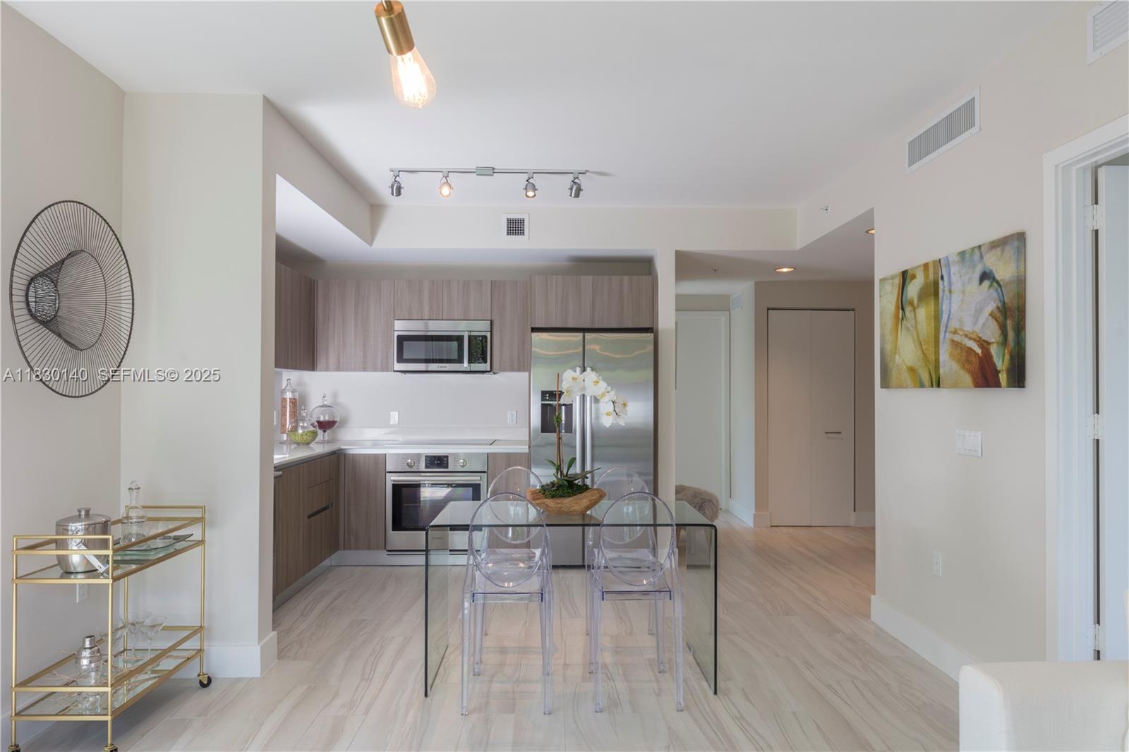 201 Southwest 17th Road, Unit 307 Miami, FL 33129 - Photo 11 of 26 a open kitchen with stainless steel appliances granite countertop a stove refrigerator and a dining table with wooden floor