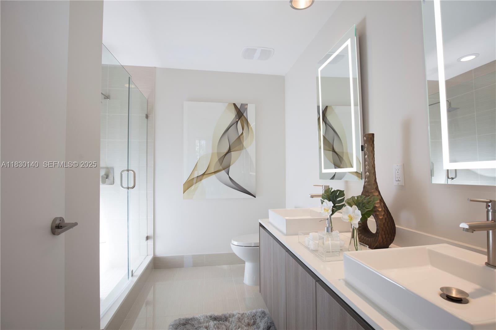 201 Southwest 17th Road, Unit 307 Miami, FL 33129 - Photo 24 of 26 a bathroom with a sink and mirror with toilet