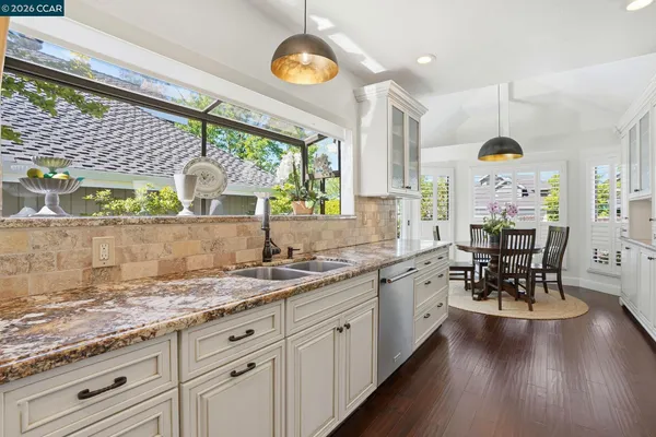 a large kitchen with a lot of counter space and a wooden floor