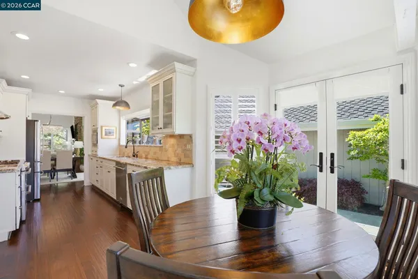 a dining room with furniture potted plants and wooden floor