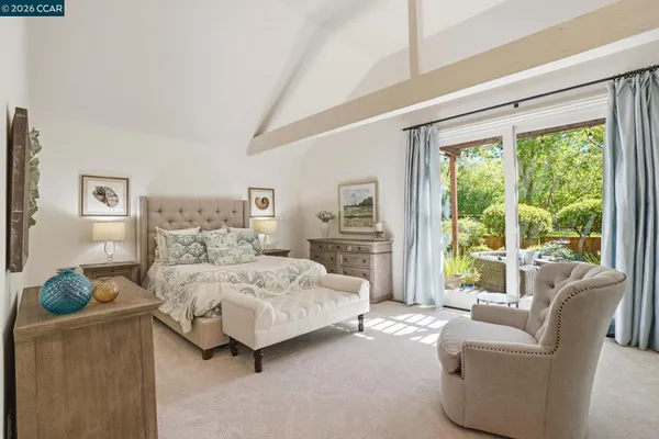a bedroom with bed and glass walk in closet
