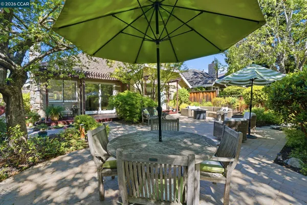 a view of a patio with table and chairs under an umbrella