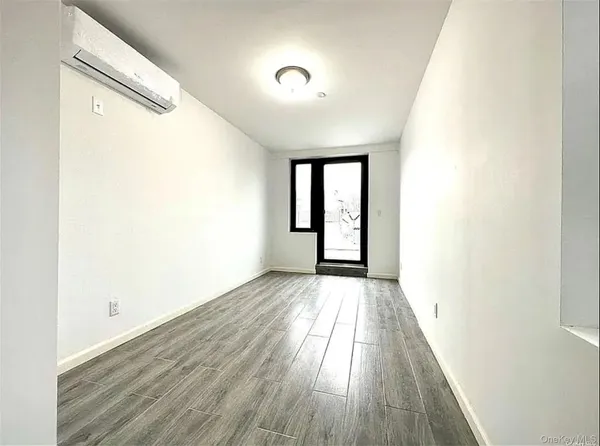 a view of a hallway with wooden floor and a window