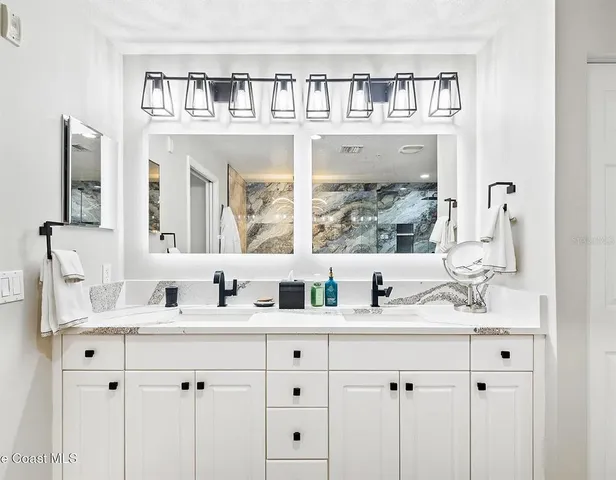 a bathroom with double vanity sinks a vanity and a mirror