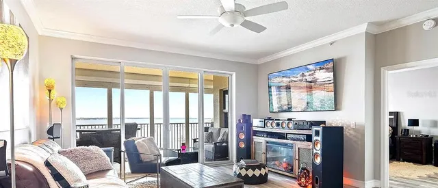 a living room with furniture a flat screen tv and a floor to ceiling window