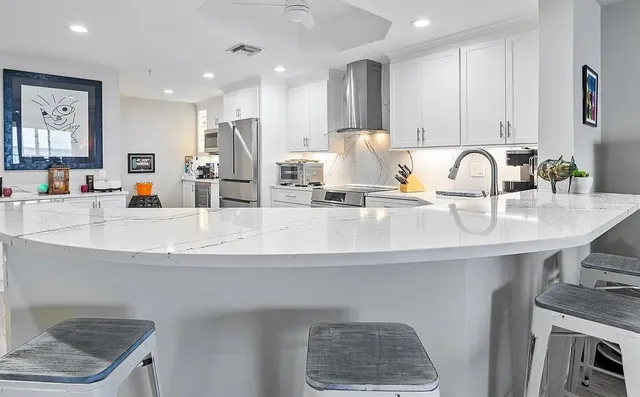 a kitchen with kitchen island a sink stainless steel appliances and cabinets