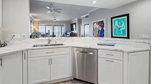 a kitchen with white cabinets and sink