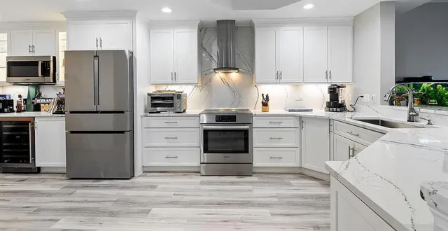 a kitchen with white cabinets and stainless steel appliances