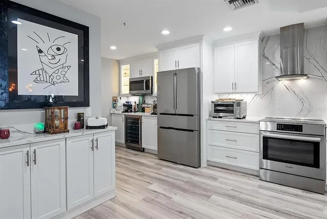 a kitchen with granite countertop a refrigerator stove and sink