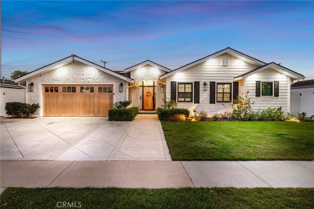 a front view of a house with a garden and plants