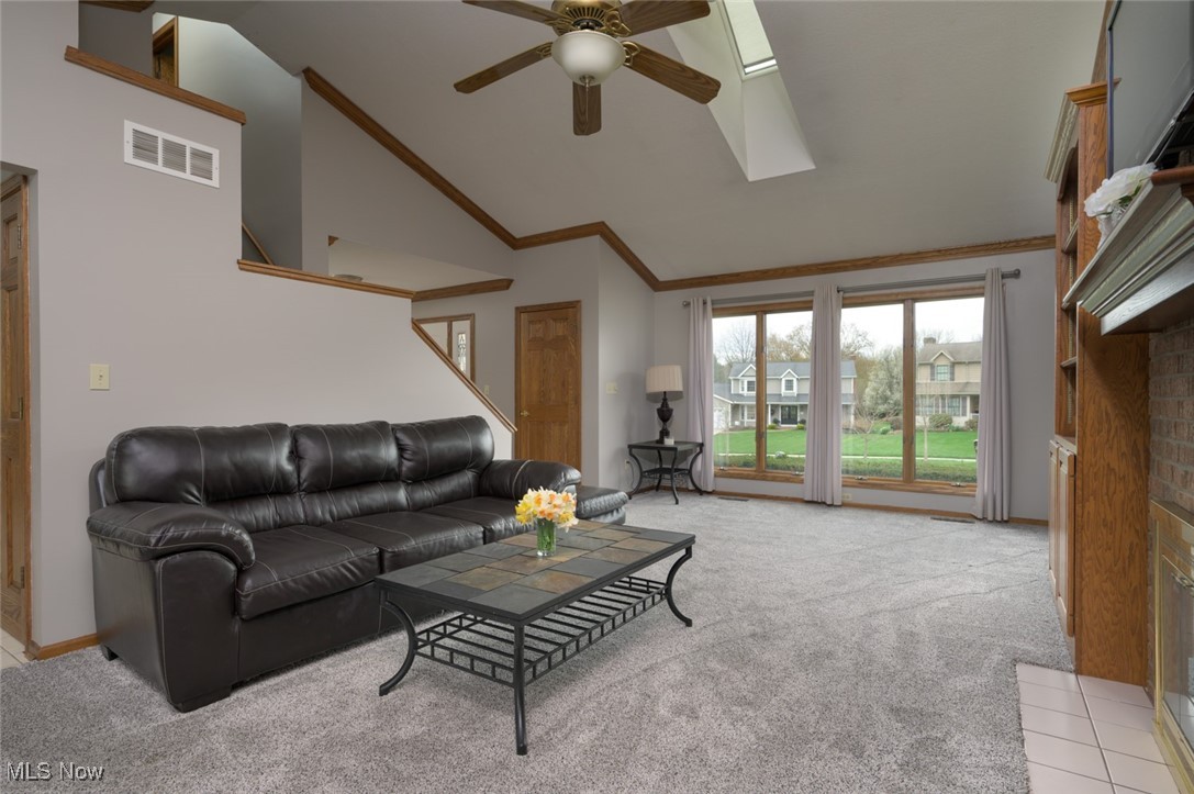 819 Bridge Road Akron, OH 44312 - Photo 15 of 33 Living area featuring ceiling fan, light carpet, crown molding, and abundant natural light