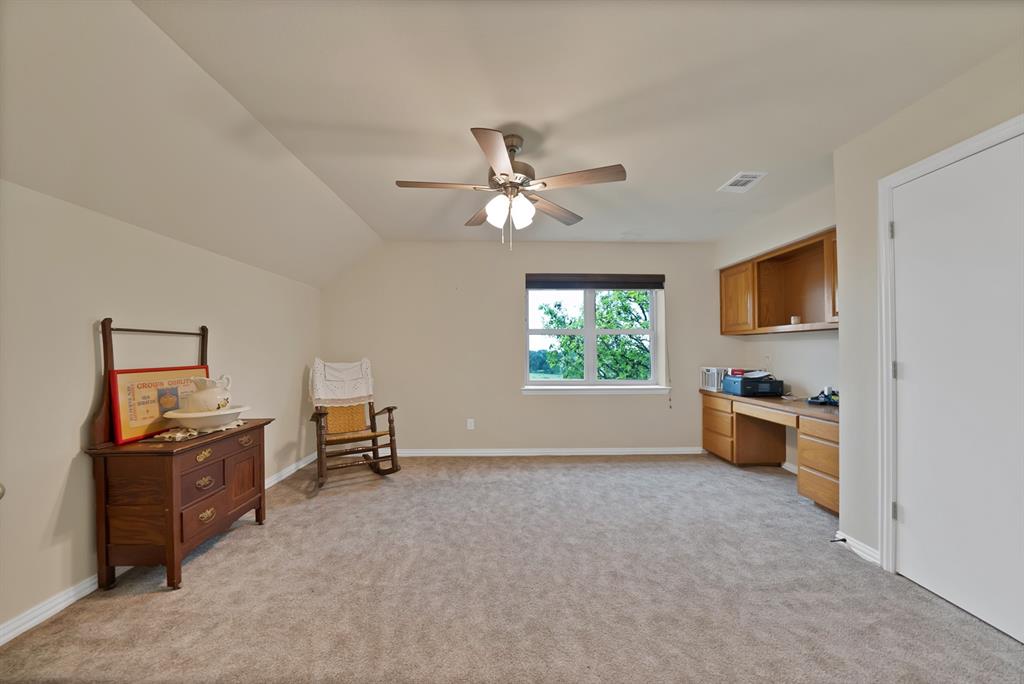 100 Shadle Ridge Court Poolville, TX 76487 - Photo 20 of 40 Carpeted room featuring a window with exterior visibility, built-in desk cabinetry, and ceiling fan with integrated lighting