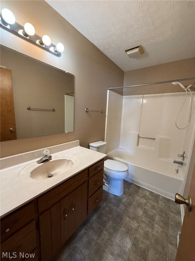 604 Harger Street Dover, OH 44622 - Photo 17 of 25 Full bath featuring vanity, shower combination, and a textured ceiling