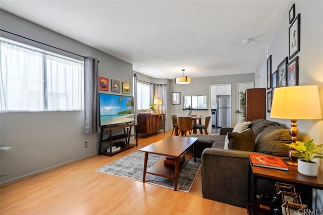 a living room with furniture a flat screen tv and a window