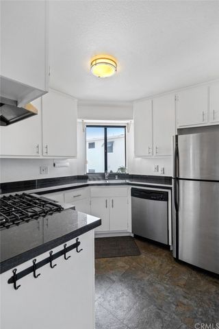 a kitchen with a refrigerator and a stove top oven