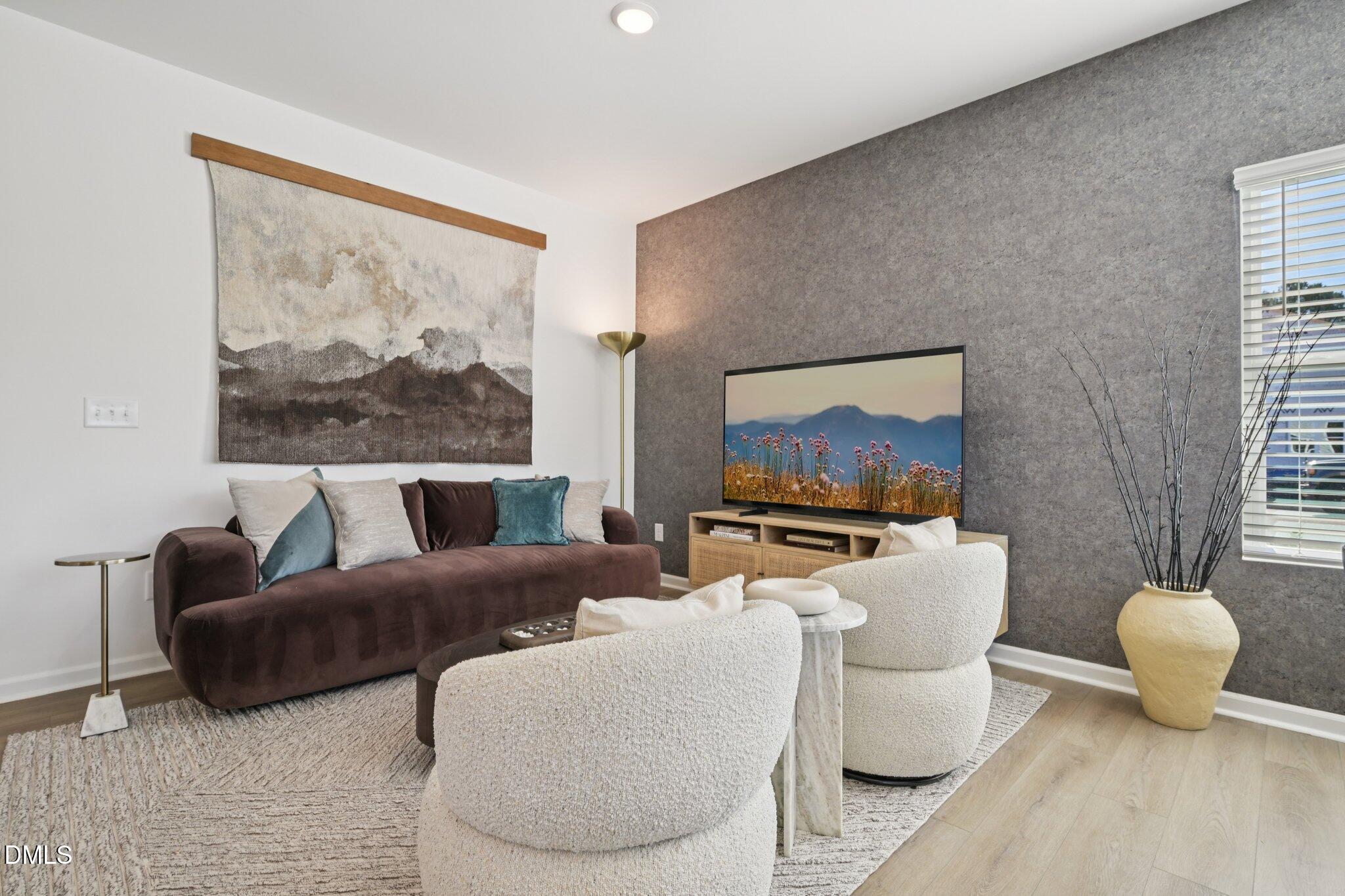 1623 Mirth Court Rolesville, NC 27571 - Photo 5 of 29 a living room with furniture a rug and a wall painting