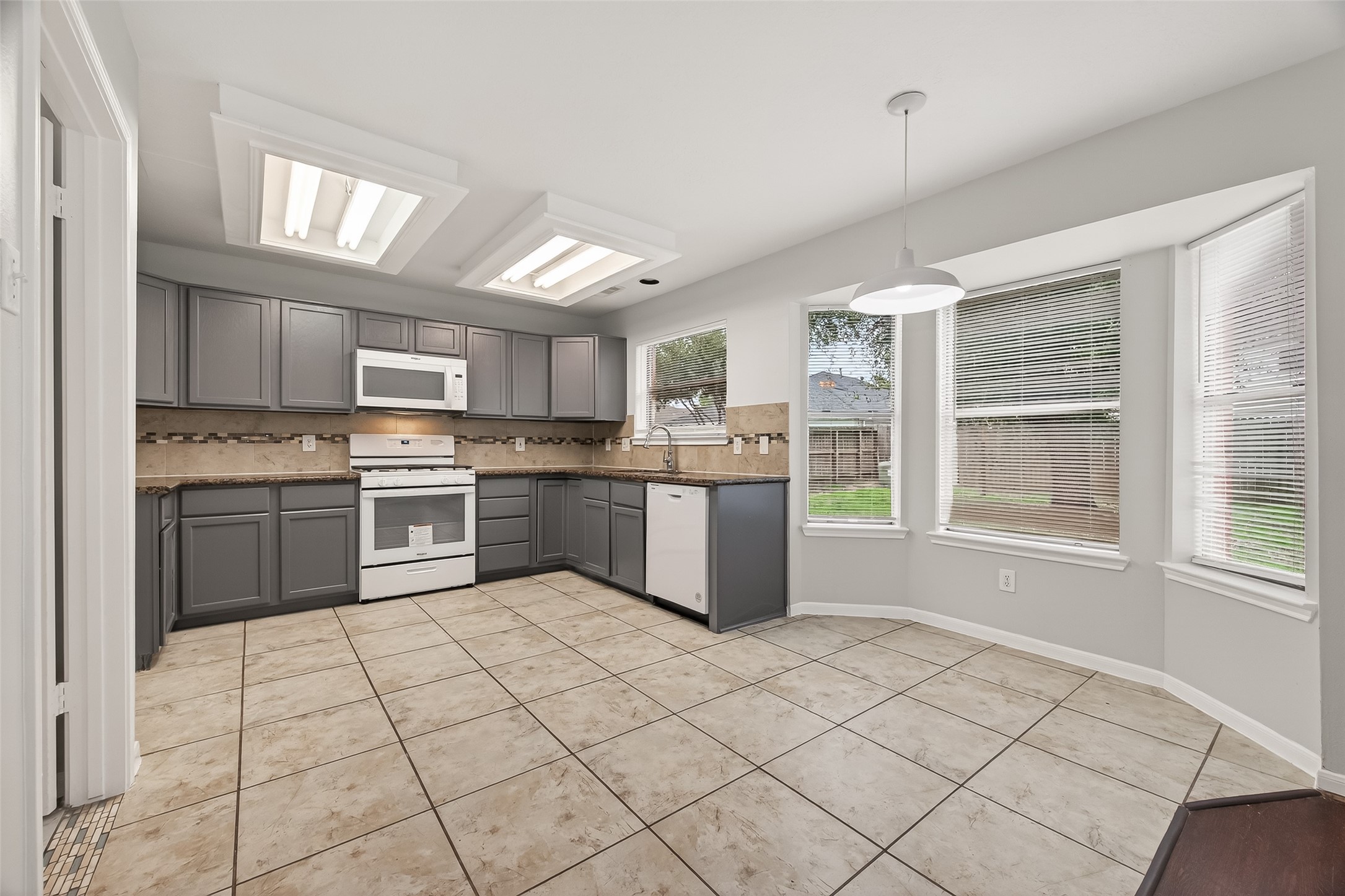 5439 Baslow Drive Katy, TX 77449 - Photo 12 of 31 a kitchen with a stove a sink dishwasher a refrigerator and cabinets
