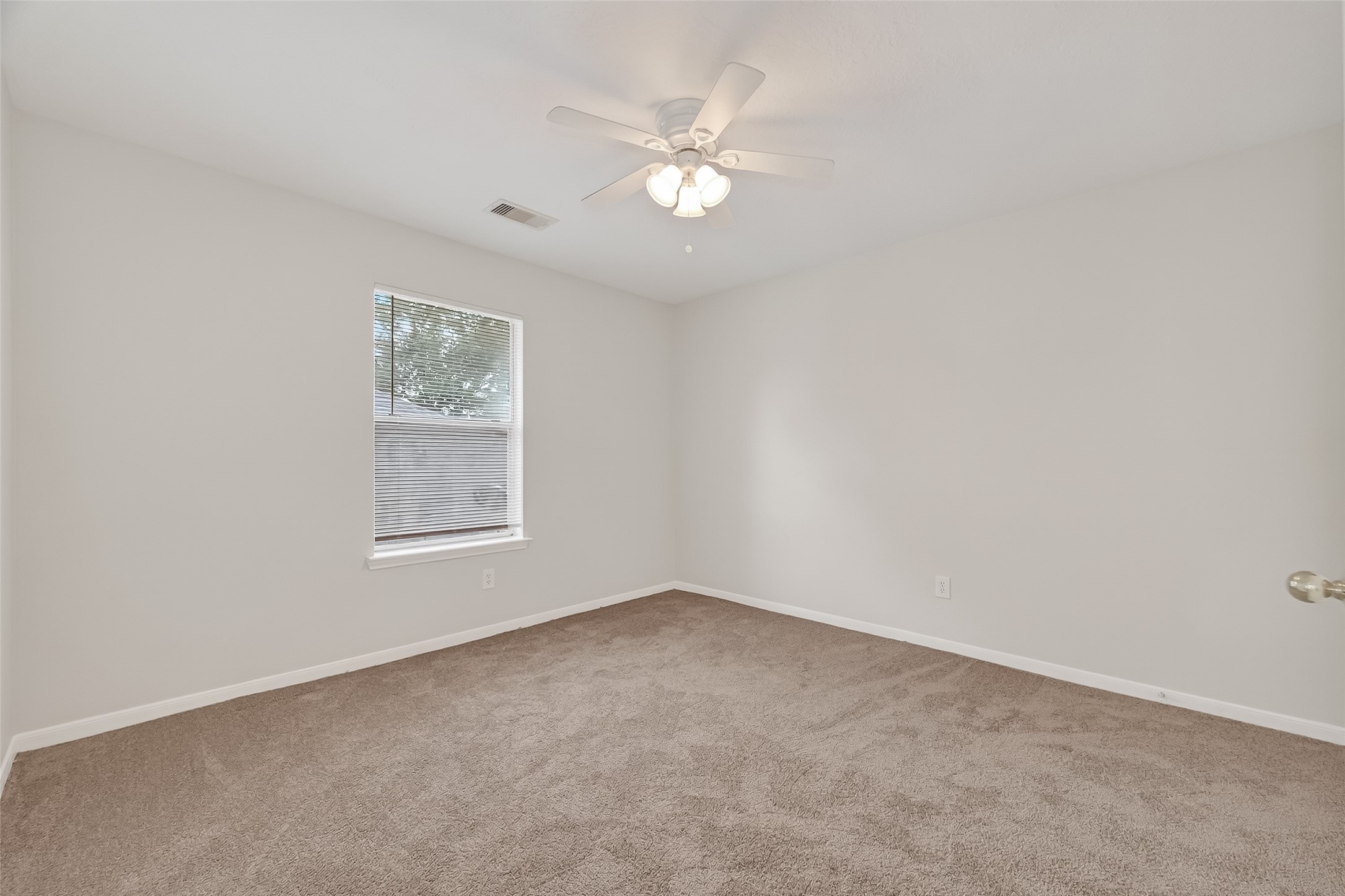 5439 Baslow Drive Katy, TX 77449 - Photo 19 of 31 an empty room with a chandelier fan and windows