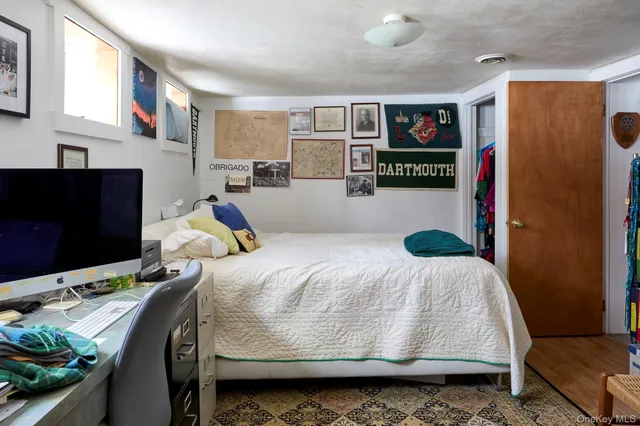 a bedroom with a bed furniture and a flat tv screen
