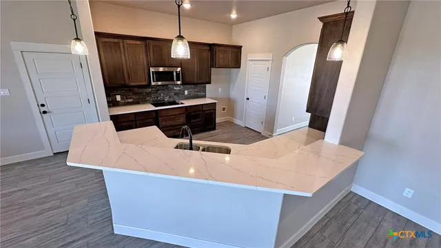 a kitchen with stainless steel appliances a refrigerator a sink a stove and microwave