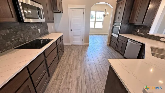 a kitchen with sink a refrigerator and wooden floor