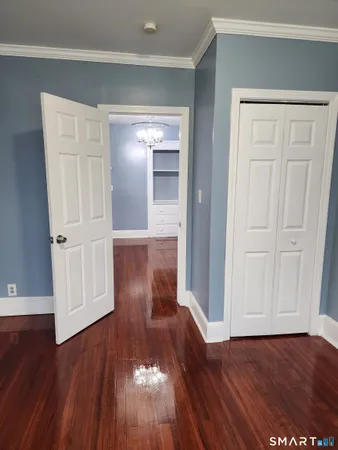 a view of empty room with wooden floor