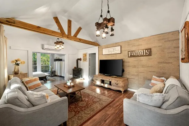 a living room with furniture a chandelier and a flat screen tv