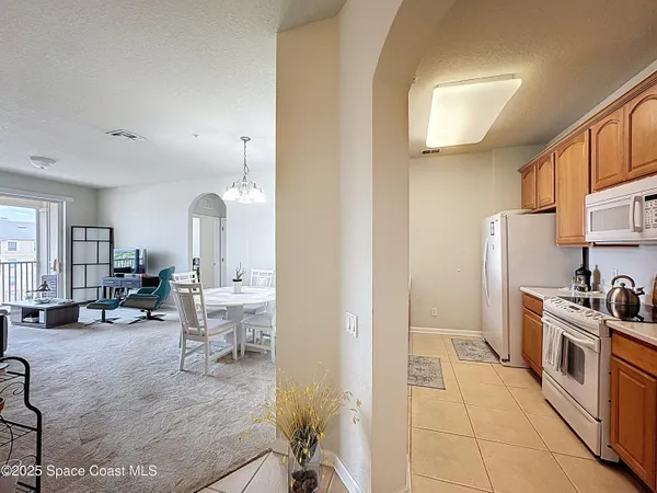 a kitchen with stainless steel appliances a refrigerator a stove a sink and white cabinets