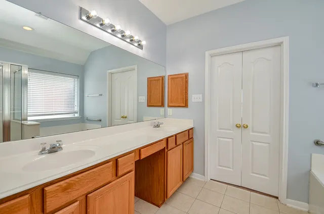 a bathroom with a double vanity sink and a mirror