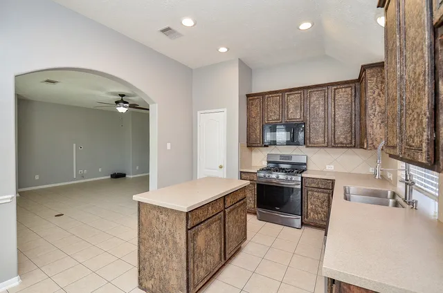 a kitchen with stainless steel appliances granite countertop a stove and a sink