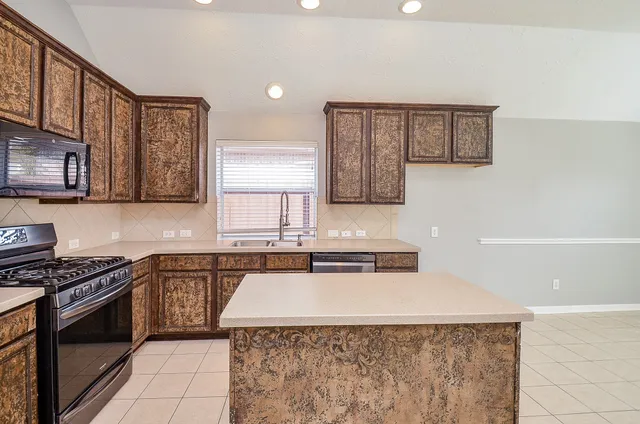 a kitchen with a stove a sink and a microwave