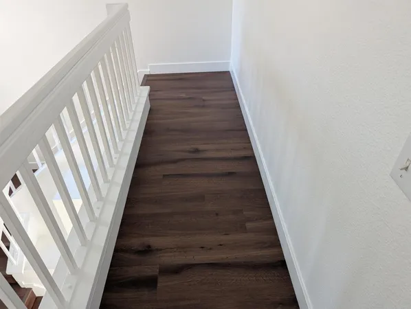 a view of staircase with wooden floor and white walls